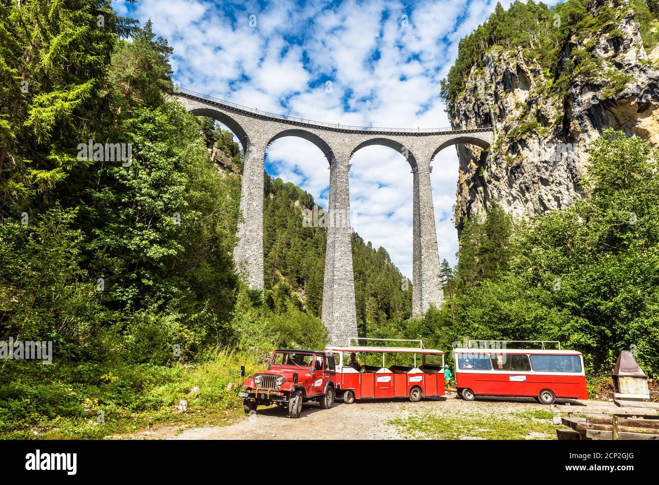 Filisur, Schweiz - 29. Juli 2019: Roter Touristenwagen bei Landwasser Viadukt. Dieser Ort ist Wahrzeichen der Schweizer Alpen. Landschaftlich reizvolle Aussicht auf Landwasser-Eisenbahn Stockfoto
