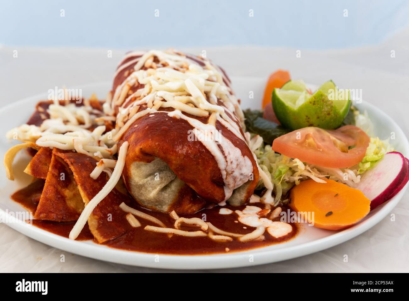 Wet Ranchero Burrito mit Reis und Bohnen serviert auf einem heißen Teller für einige leckere mexikanische Speisen. Stockfoto