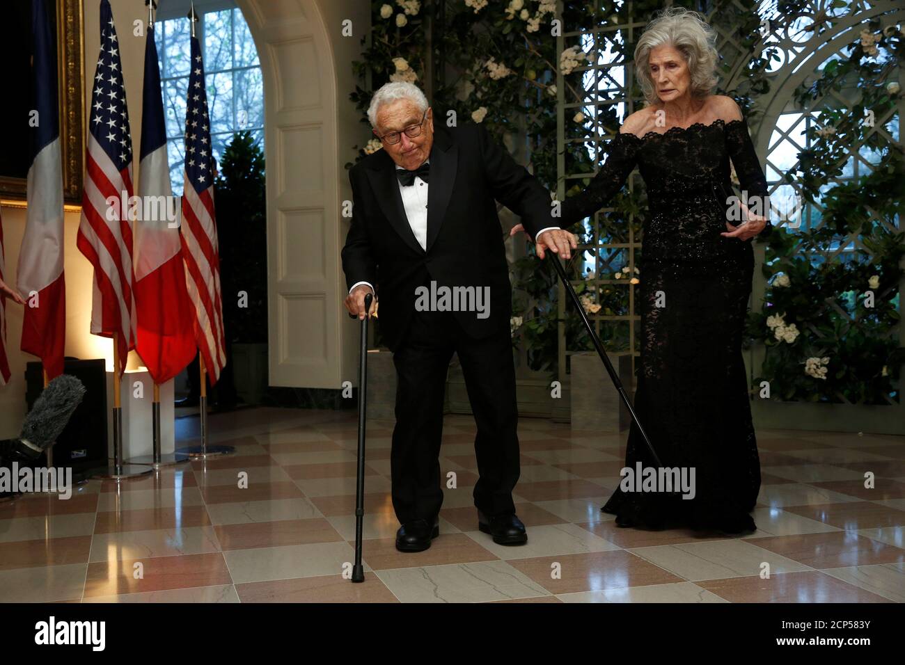 Der ehemalige US-Außenminister Henry Kissinger wird von seiner Frau Nancy Kissinger beim Staatsessen zu Ehren des französischen Präsidenten Emmanuel Macon im Weißen Haus in Washington, USA, am 24. April 2018, ins Stadionfest aufgenommen. REUTERS/Joshua Roberts Stockfoto