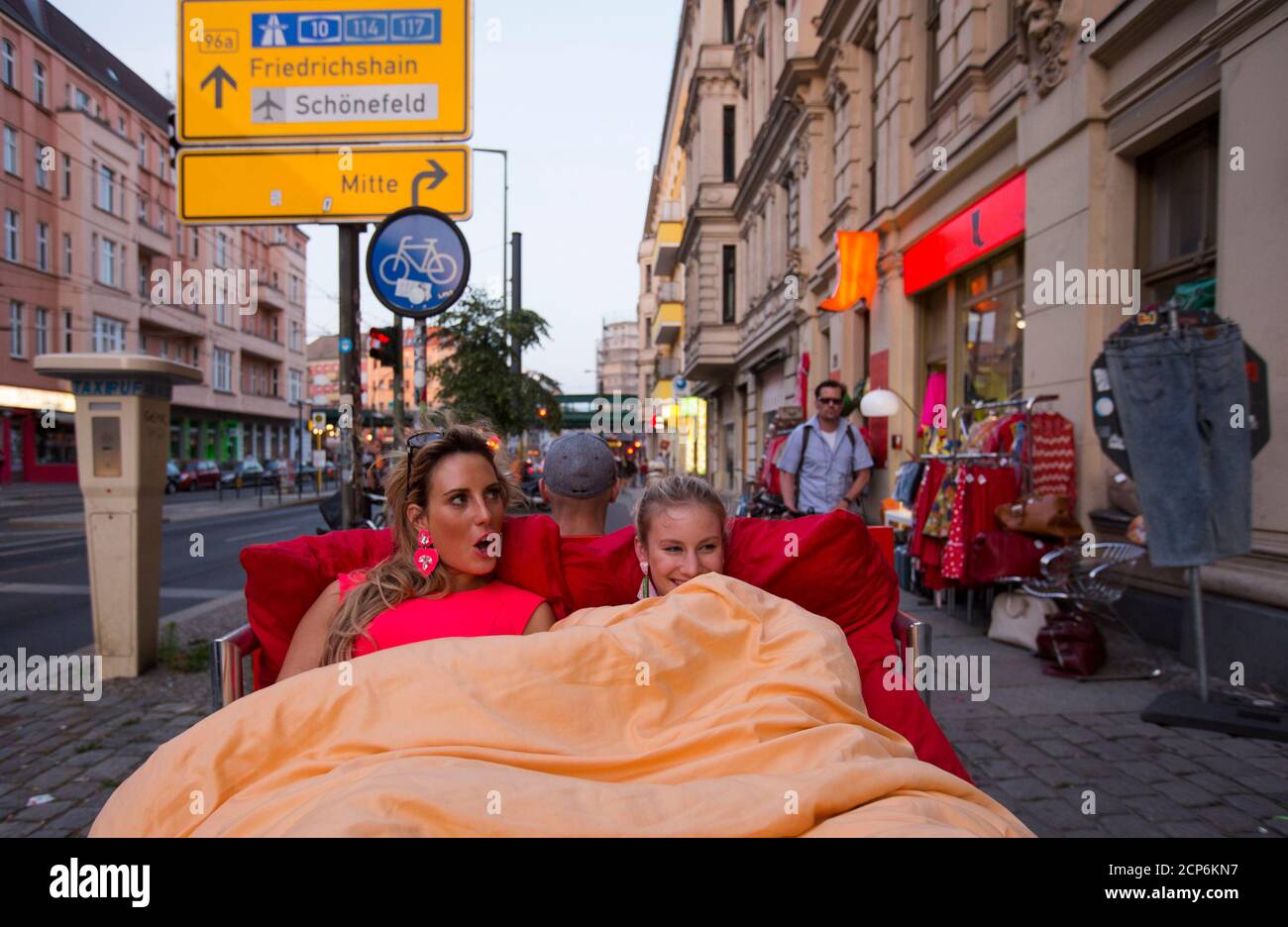 Touristen Caro (L) und Anna aus München fahren auf einem "Bett Bike" im  Bezirk Prenzlauer Berg in Berlin 5. Juli 2013. Richard Eckes des  horizontalen Berlin bietet Touristen reitet auf einem Doppelbett