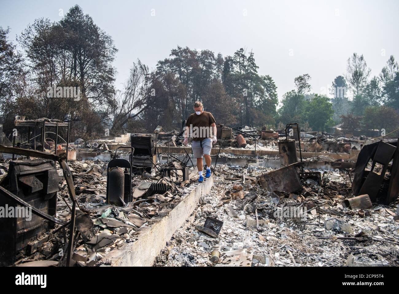 Talent, Oregon, 18. September 2020. Zach Kuhllow prüft die Überreste seines Hauses auf alles, was gerettet werden kann. Sein Sohn, der jetzt 10 Jahre alt ist, wurde im Haus geboren. In Talent, etwa 20 Meilen nördlich der kalifornischen Grenze, wurden Häuser bis zur Unkenntlichkeit verkohlt. Im Westen der USA brennen laut dem National Interagency Fire Center mindestens 87 Waldbrände. Sie haben mehr als 4.7 Millionen Hektar in Fackeltau - mehr als sechsmal so viel wie Rhode Island. Quelle: Chris Tuite/Image Space/Media Punch/Alamy Live News Stockfoto