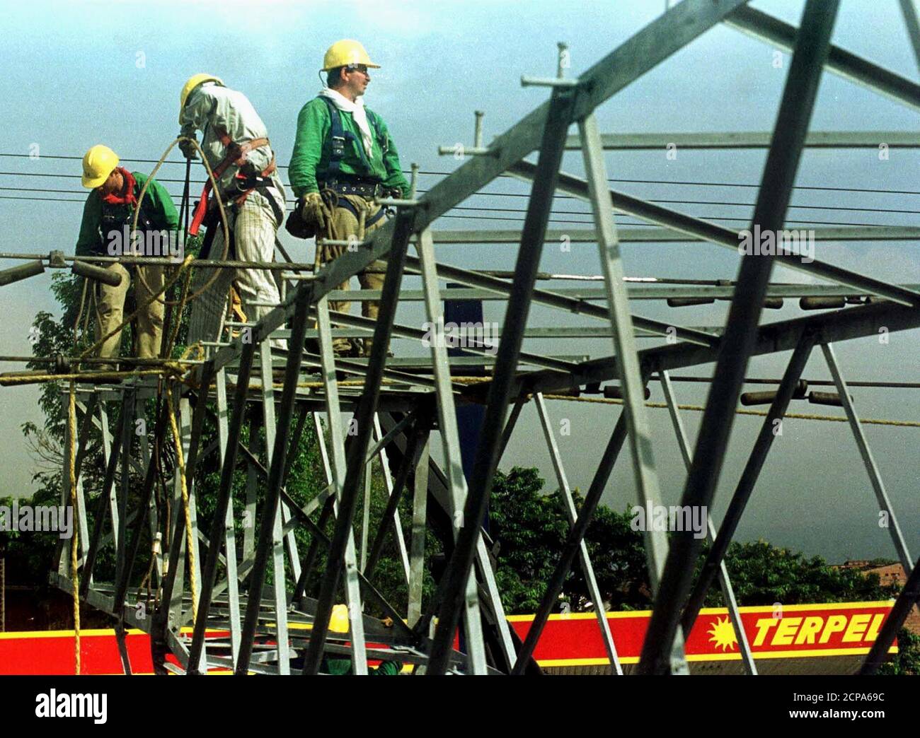 Arbeiter reparieren elektrische Masten, nachdem eine Bombe in Medellin, Antioquia, einer Provinz nordwestlich von Bogota, explodierte, 3. August 2000. Mutmaßliche marxistische Rebellen bombardierten mitten in einem nationalen Streik von 700,000 Staatsarbeitern gegen staatliche Sparmaßnahmen einen Hochspannungsmast im Industriesektor von Medellin. JMG/CM Stockfoto