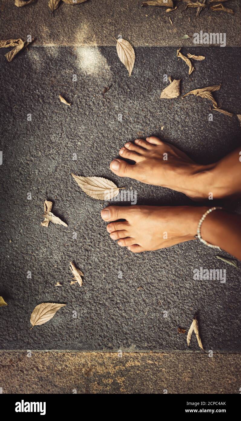 Willkommen Herbst Hintergrund. Nahaufnahme Konzept Foto eines Barfuß Frauen Füße und trockene Blätter. Thema Herbstsaison. Der Sommer ist vorbei. Stockfoto