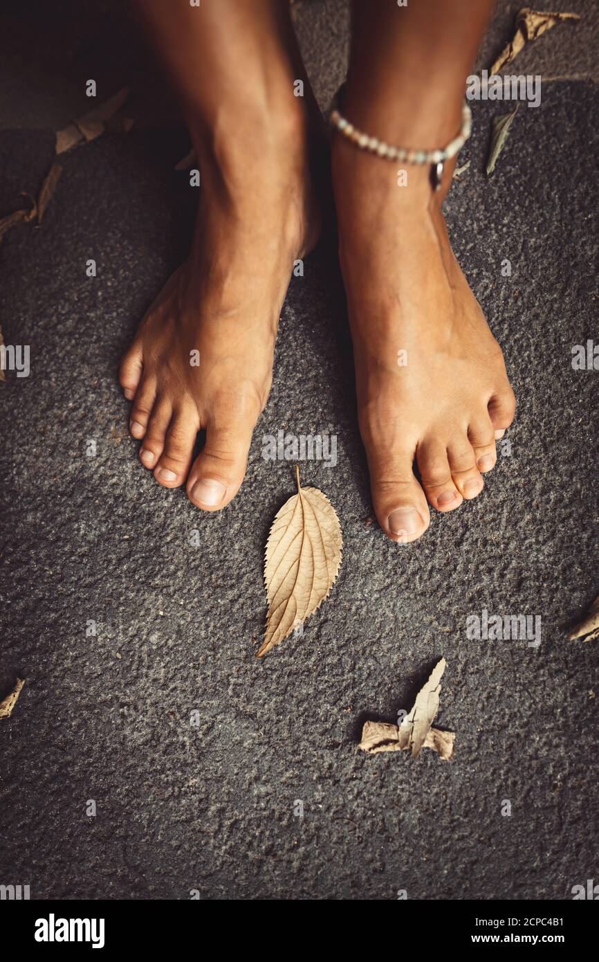 Willkommen Herbst Hintergrund. Nahaufnahme Konzept Foto eines Barfuß Frauen Füße und trockene Blätter. Thema Herbstsaison. Stockfoto