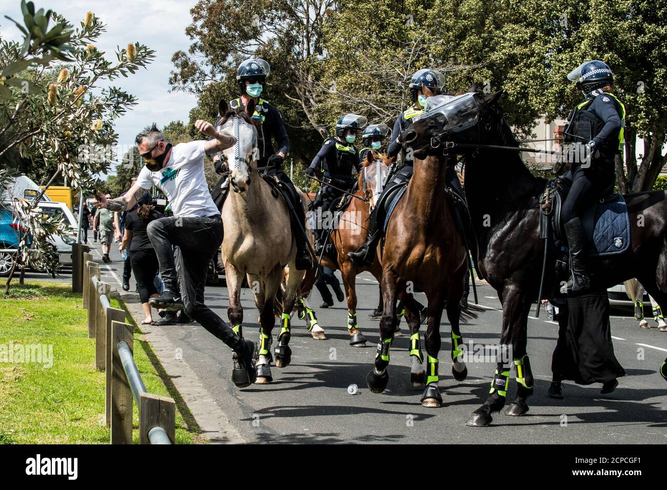 Melbourne, Australien. 19. September 2020. Ein Protestler springt einen Zaun, um vor Victoria zu fliehen Polizisten beritteten in einer Strandstraße in Elwood während eines Anti-Maske- und Anti-Lockdown-Protests, die im Elsternwick Park, Melbourne, Australien, begonnen hatten. Kredit: Michael Currie/Alamy Live Nachrichten Stockfoto