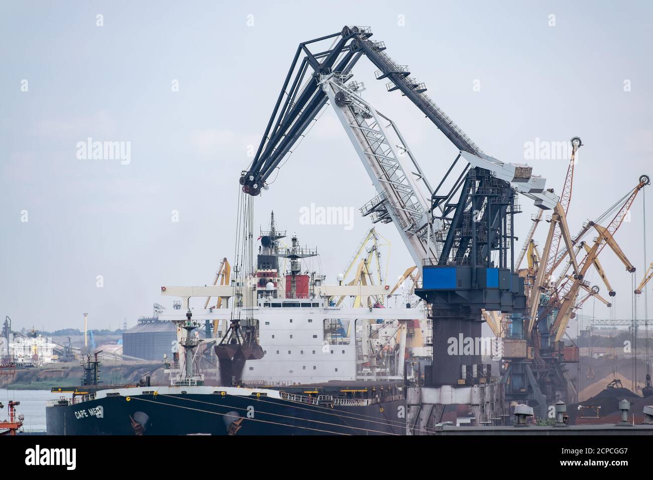 Krane am Frachtschiffhafen, die den Massengutfrachter verladen Mit Eisenerz oder Kohle Stockfoto