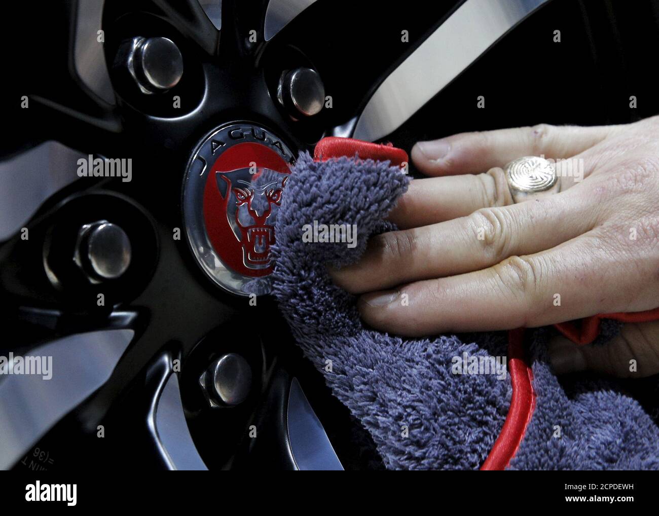 Ein Arbeiter poliert ein Rad an einem Jaguar 2017 F-TYPE SVR während der Medienvorschau der New York International Auto Show 2016 in Manhattan, New York, 23. März 2016. REUTERS/Brendan McDermid Stockfoto