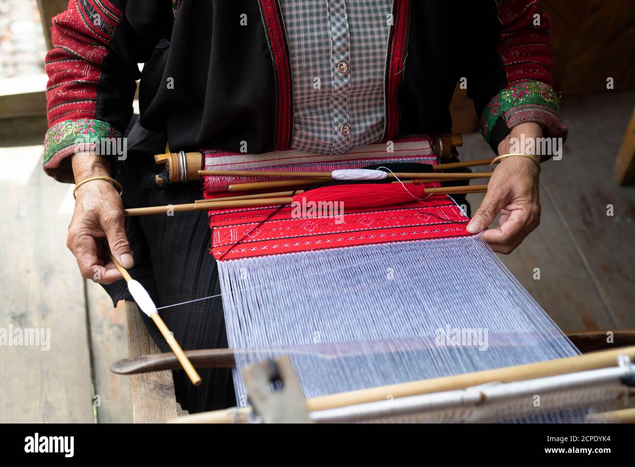 Eine Frau webt auf einem traditionellen Webstuhl im Dorf Dazhai. Stockfoto
