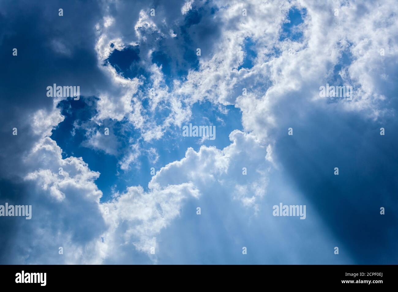 Blauer Himmel mit Wolken und Sonnenstrahlen Stockfoto