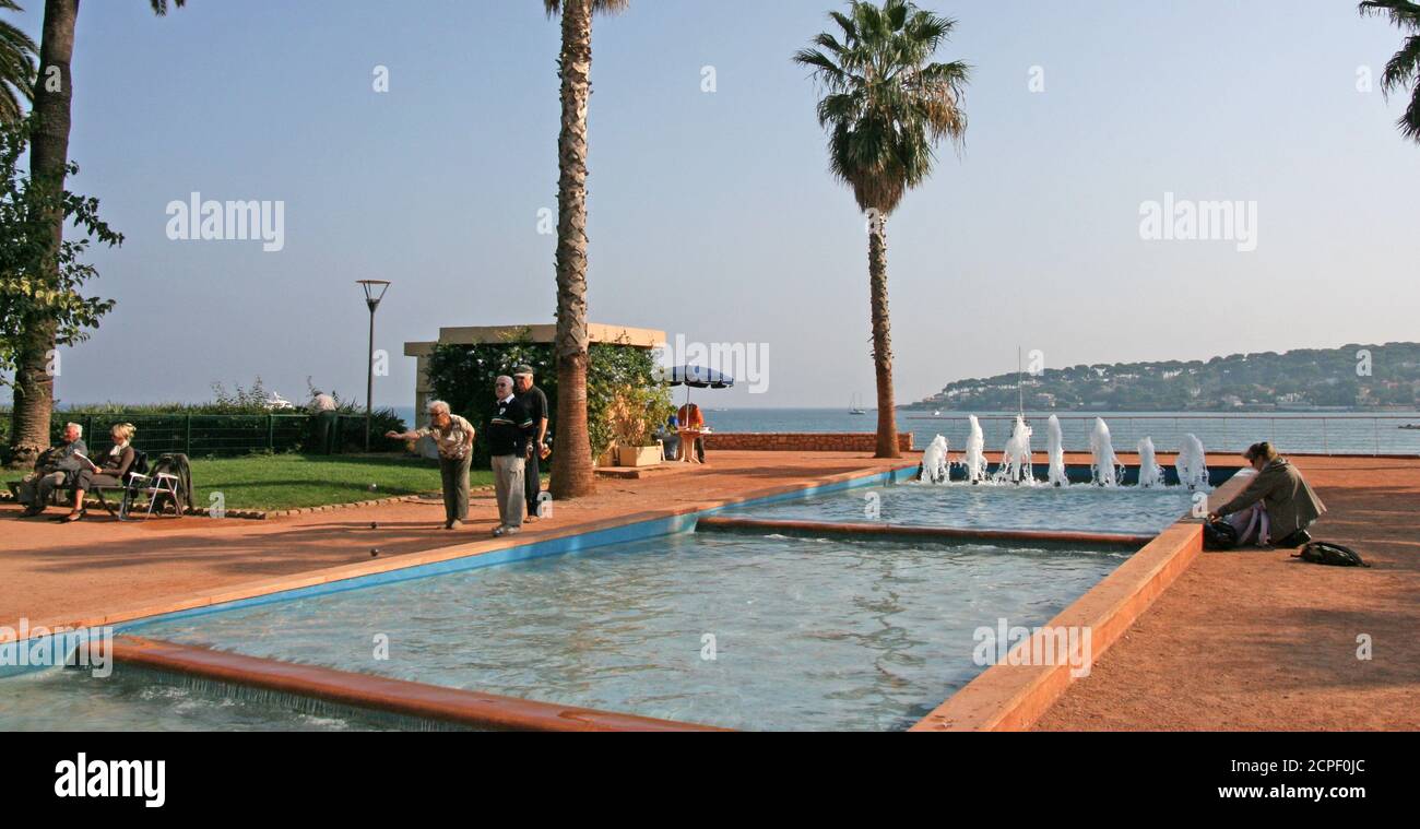 Petanque Spiel auf der Strandpromenade. Seriöse, prestigeträchtige Rentner. Konzentrieren Sie sich auf kleine gelbe Kugeln. Weibliche Spielerin. Stockfoto