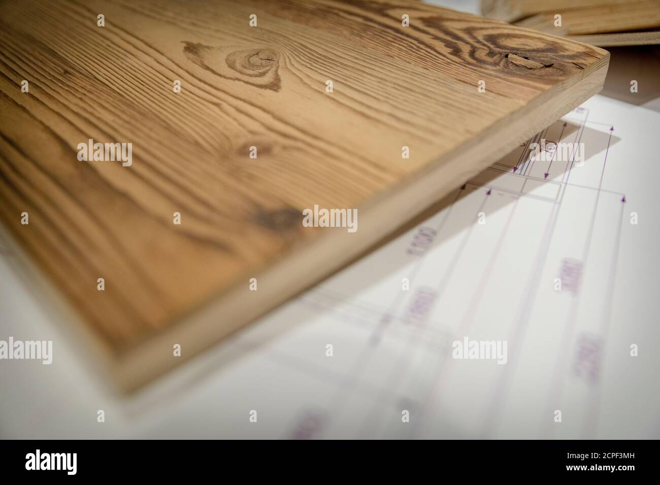 Die Zimmerei, die Holzmöbel, die technische Zeichnung und die Muster verschiedener Holzarten unter dem Schreibtisch Stockfoto