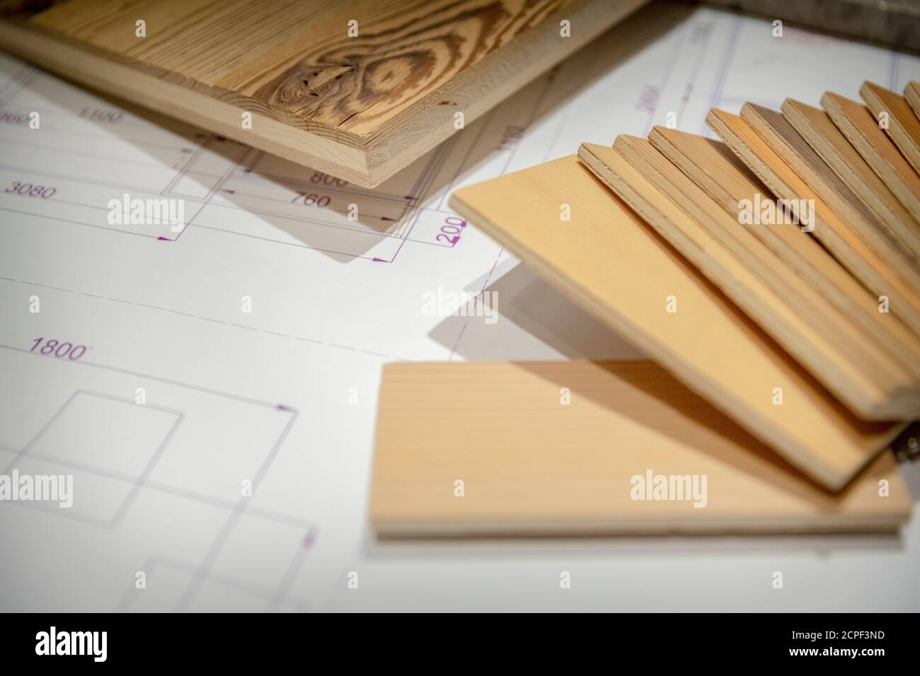 Die Zimmerei, die Holzmöbel, die technische Zeichnung und die Muster verschiedener Holzarten unter dem Schreibtisch Stockfoto