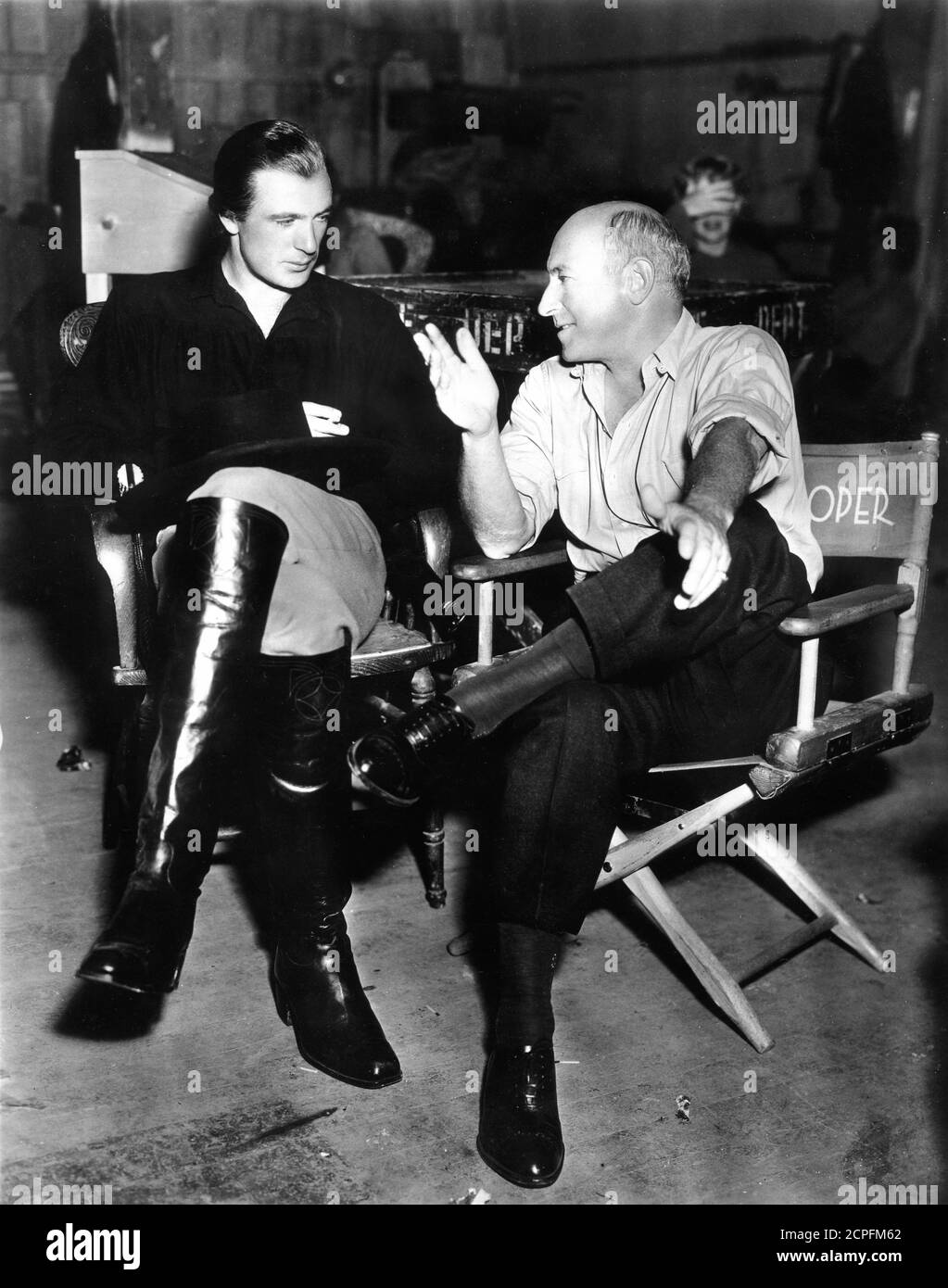 GARY COOPER in Kostüm als Wild Bill Hickok und CECIL B. DeMille am Set offen während der Dreharbeiten VON THE PLAINSMAN 1936 Regisseur CECIL B. DeMille Paramount Pictures Stockfoto