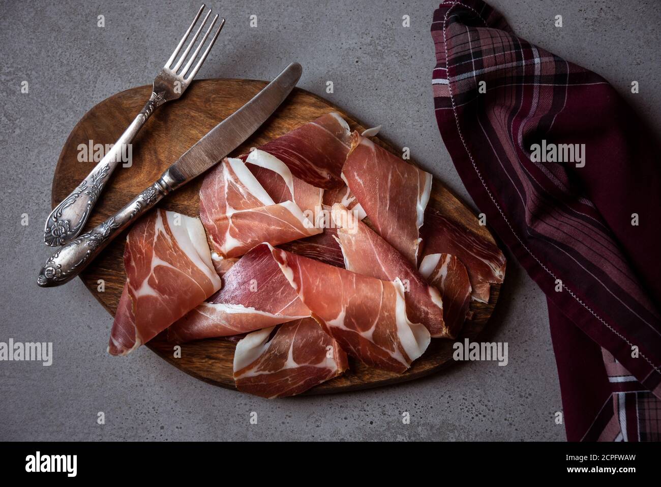 Italienischer Prosciutto oder Jamon mit Rosmarin, rohem Schinken Stockfoto