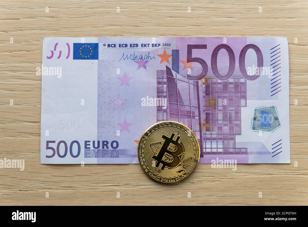 Symbolbild digitale Währung, physische Münze Bitcoin, auf Euro-Banknote Stockfoto
