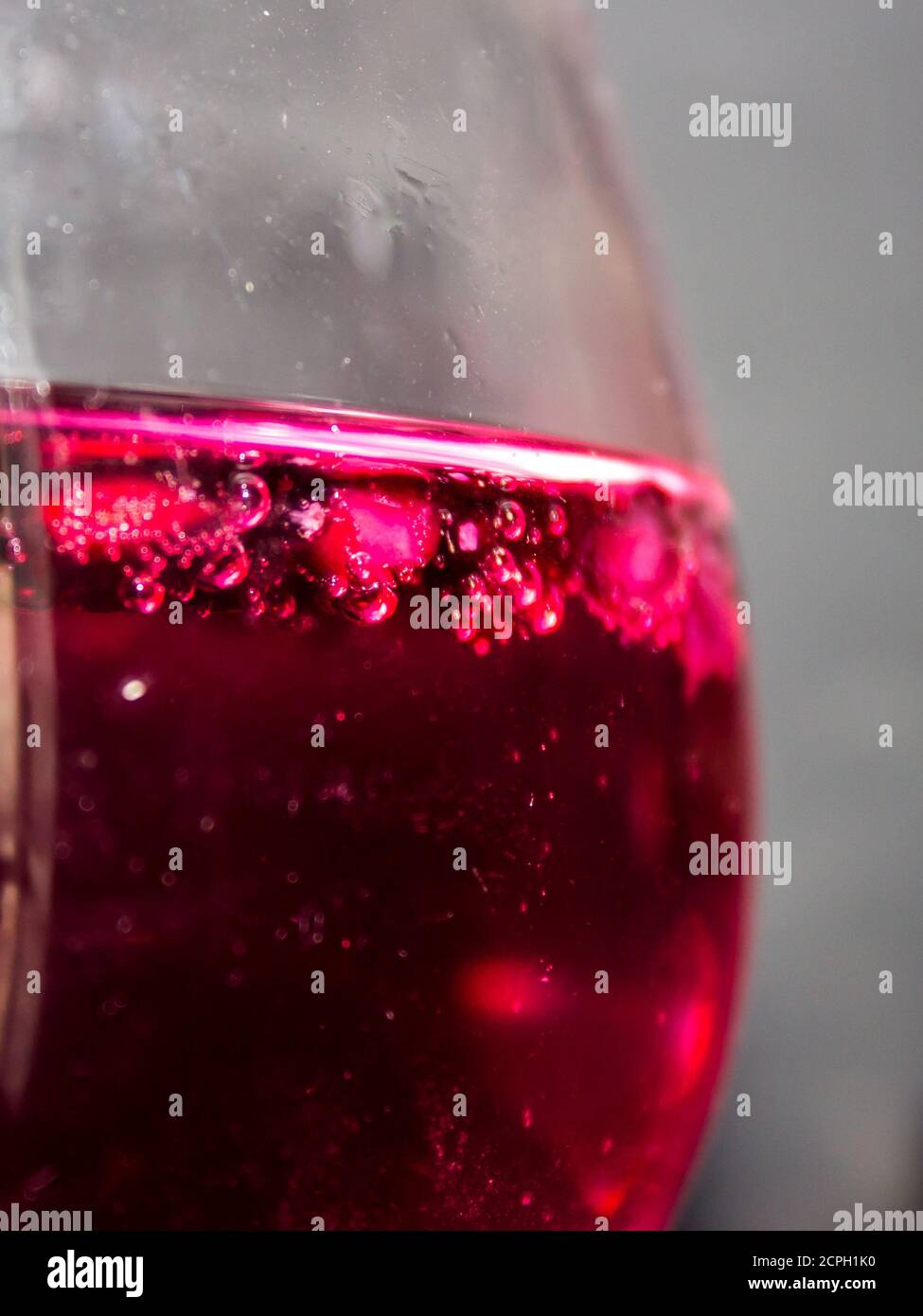 Nahaufnahme von Granatapfelpipetten in einem roten Gin mit Granatapfelgeschmack und Tonic-Cocktail Stockfoto