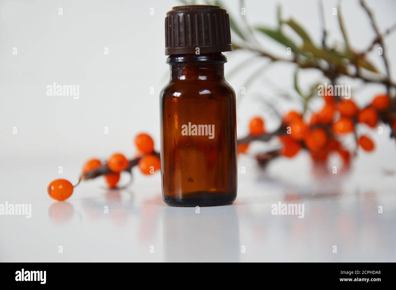 Sanddornbeeren Cluster und Ölflasche Glas isoliert auf a Weißer Hintergrund Stockfoto