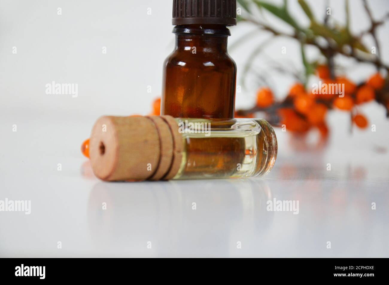 Sanddornbeeren Cluster und Ölflasche Glas isoliert auf a Weißer Hintergrund Stockfoto