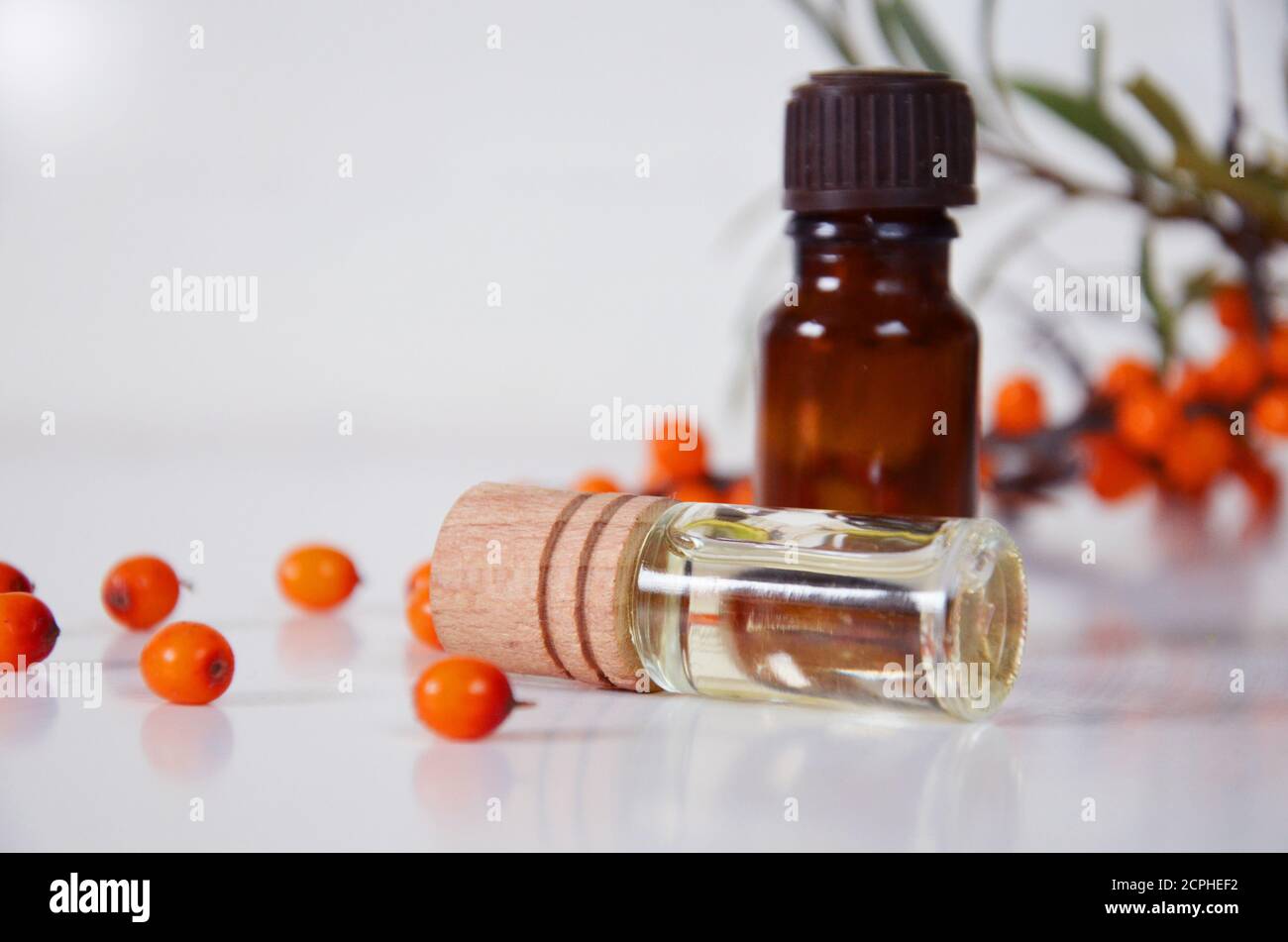 Sanddornbeeren Cluster und Ölflasche Glas isoliert auf a Weißer Hintergrund Stockfoto