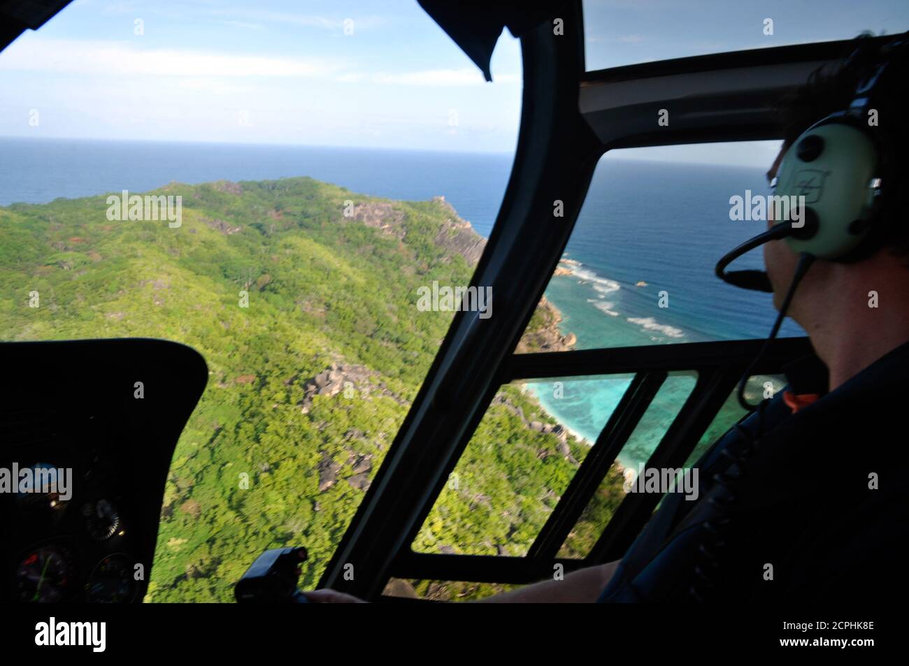 La Digue Island / Seychellen - 3. August 2010: Blick auf die tropische Insel durch das Hubschrauberfenster mit dem Piloten Stockfoto