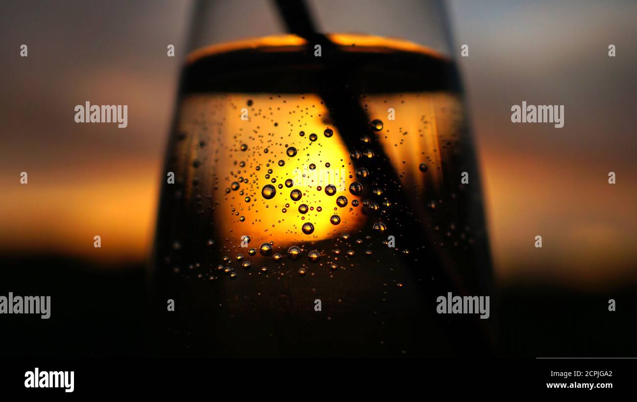 Sonnenuntergang Dämmerung scheint vorbei durch klare transparente Vase Schüssel Glas Tasse Wasserblasen leuchten Stockfoto