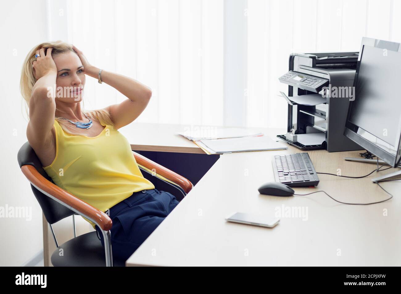 Frau packte ihren Kopf, während sie im Büro arbeitete Stockfoto