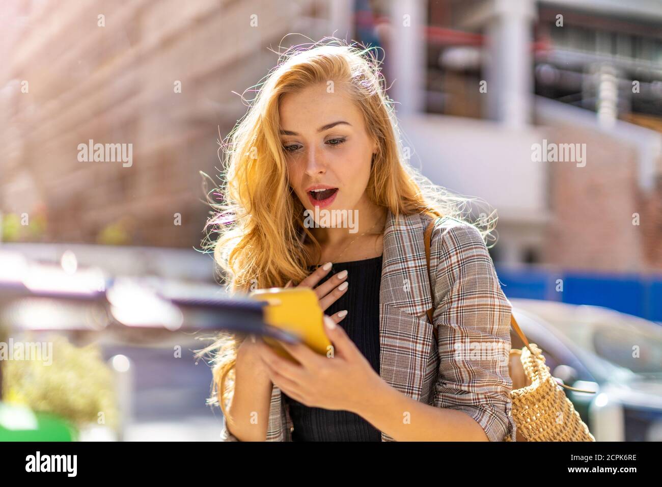 Attraktive junge Frau mit Smartphone in der Stadt Stockfoto