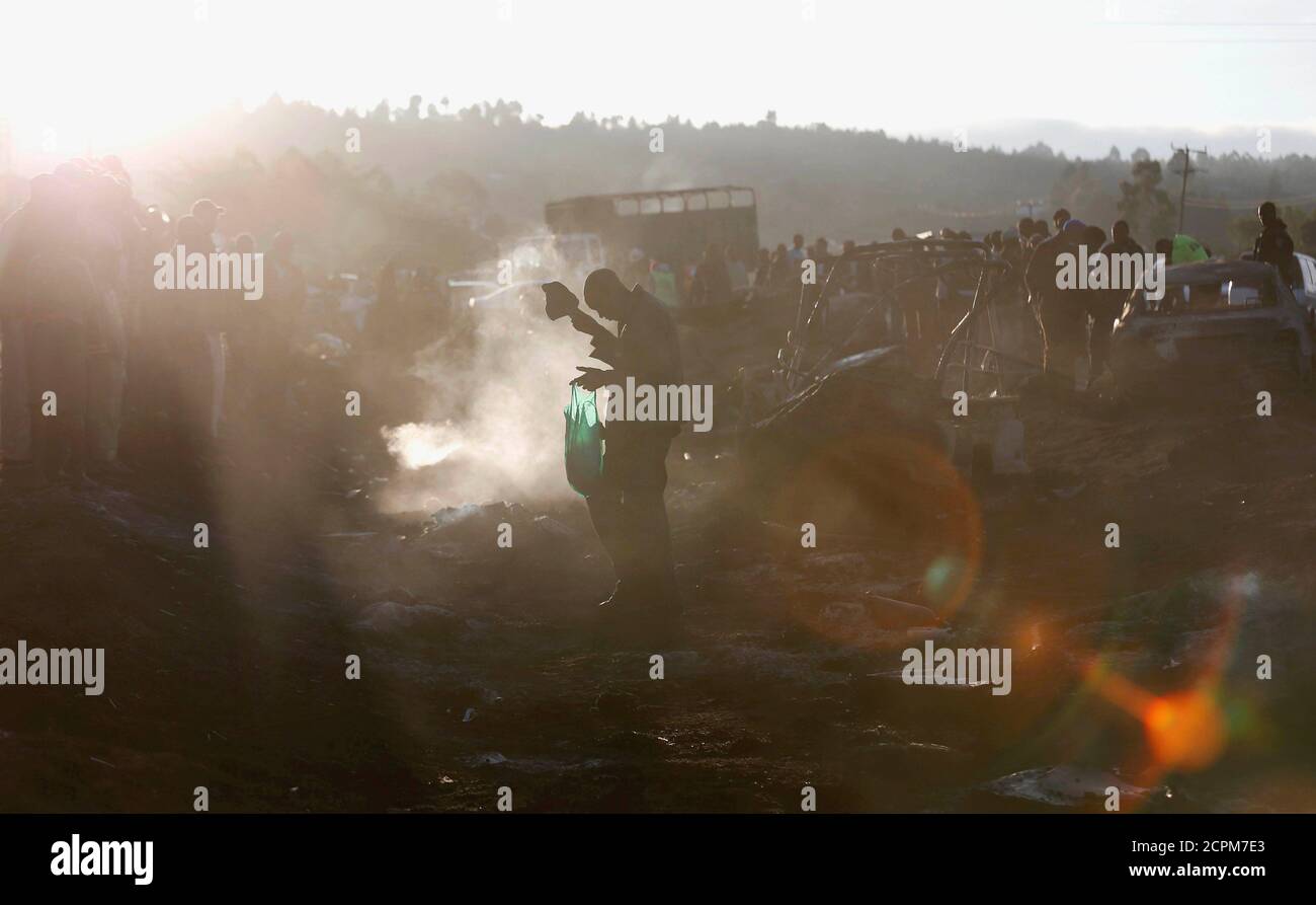 Ein Mann geht im Rauch, während er die Wracks von Autos einschätzt, die verbrannt wurden, nachdem ein Feuerball eines Tankers mehrere Fahrzeuge verschlang und mehrere Menschen getötet hatte, nahe der Stadt Naivasha im Rift Valley, westlich von Kenias Hauptstadt Nairobi, 11. Dezember 2016. REUTERS/Thomas Mukoya TPX-BILDER DES TAGES Stockfoto
