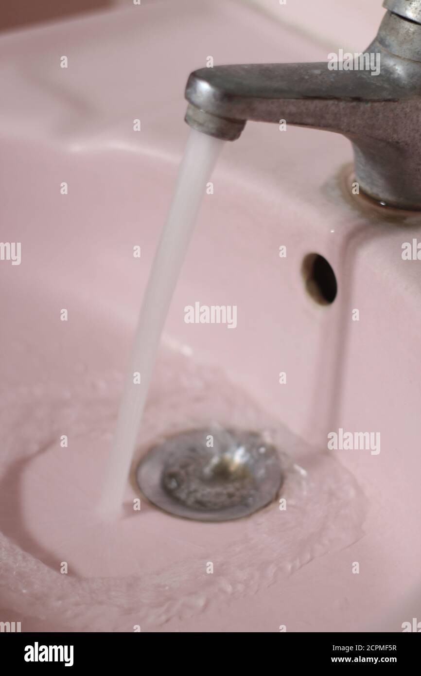 Wasser fließt aus dem Wasserhahn im Badezimmer Stockfoto