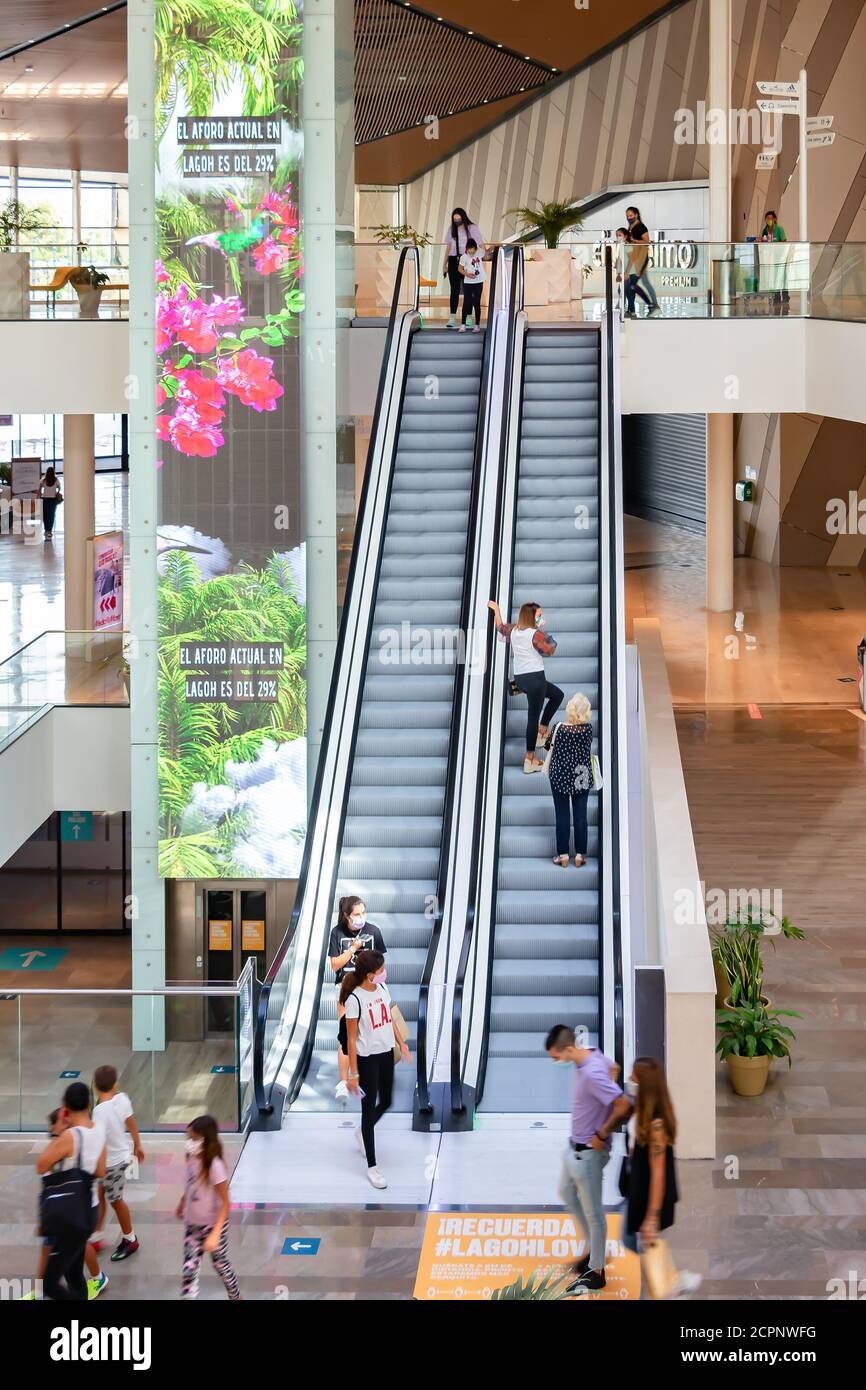 Sevilla, Spanien - 18. September 2020: Menschen an der automatischen Treppe des Lagoh Shopping Centers tragen Schutzmaske wegen Coronavirus covid-19. Neue Norm Stockfoto