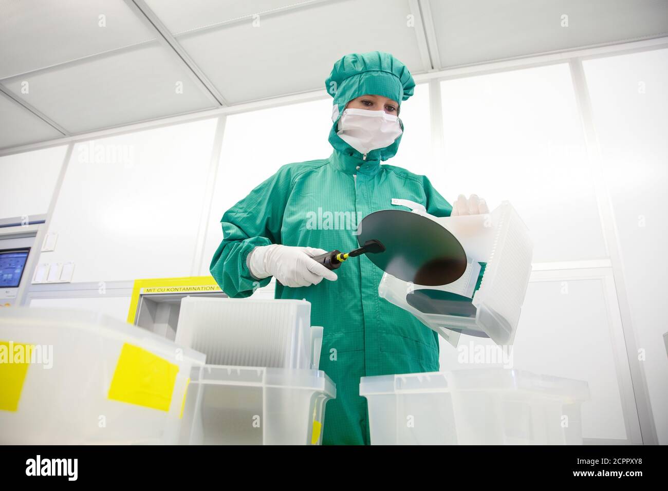 Duisburg, Nordrhein-Westfalen, Deutschland - Hochtechnologie im Ruhrgebiet. Ein Mikrotechnologe im Wafer-Handling im Reinraum am Stockfoto
