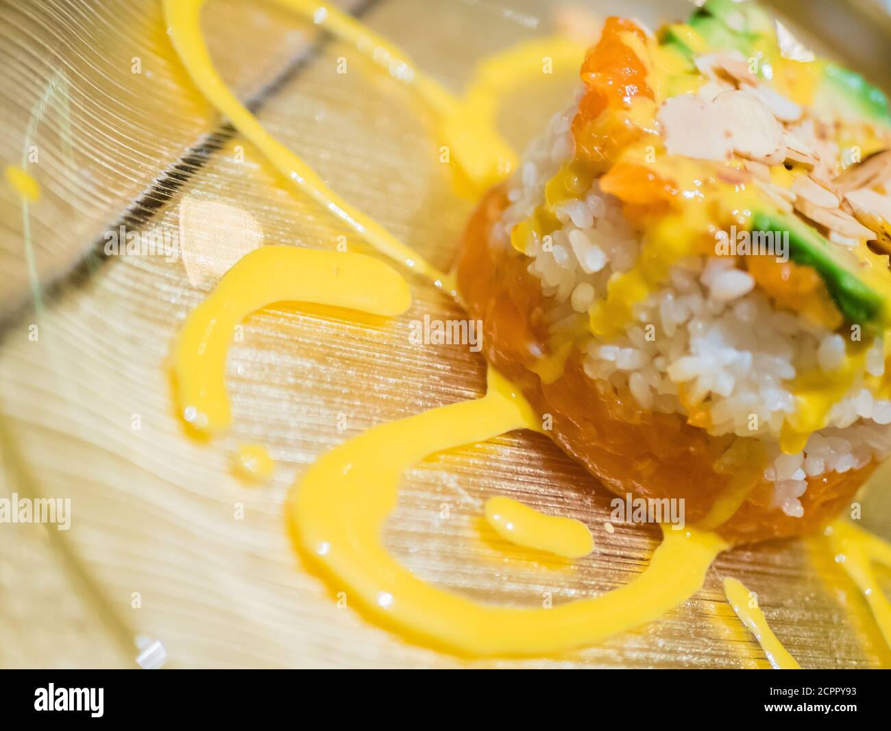 Typisch japanisches Gericht mit Sushi, Reis und Fisch, mit Sauce, Salat, Sushimi und Sesam. Japanischer Burger mit Reis, Lachs, Avocado, Mandeln und d Stockfoto