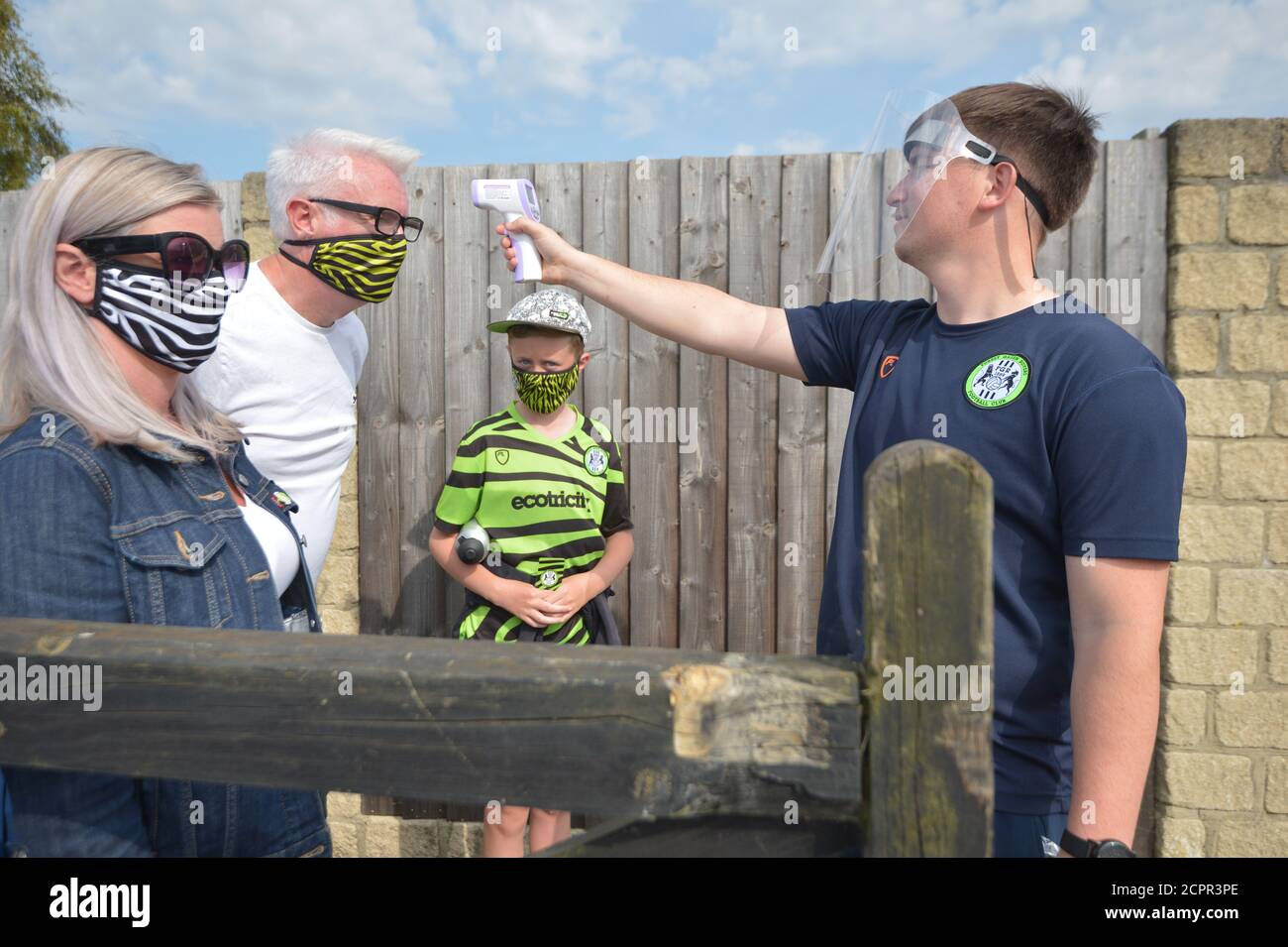 Ein Steward in PPE testet die Temperatur eines Fans während des Sky Bet League Two Spiels im New Lawn, Nailsworth. Stockfoto