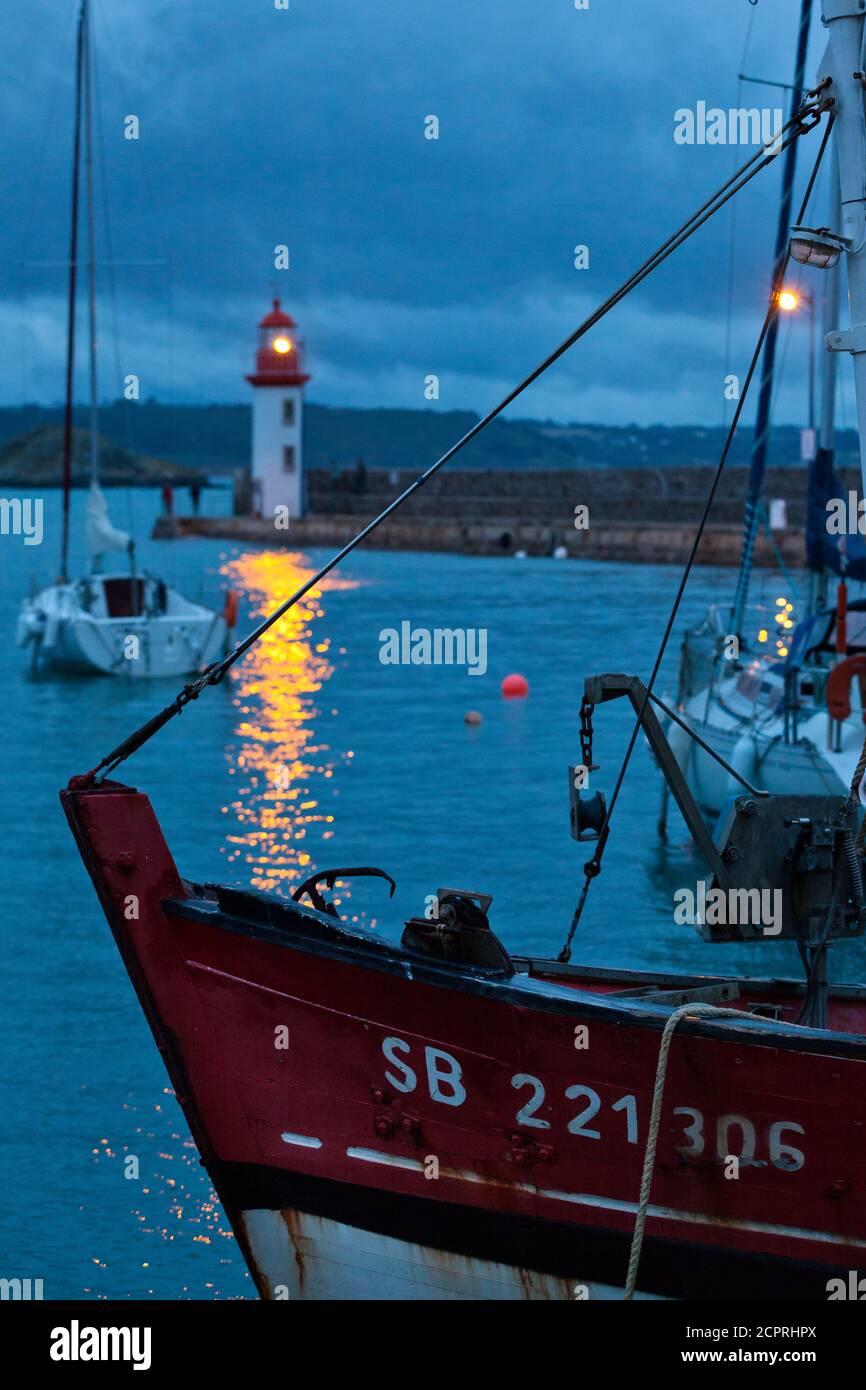 Am Abend am Leuchtturm von Eruqy - Hafeneinfahrt mit Booten. Bretagne, Frankreich Stockfoto