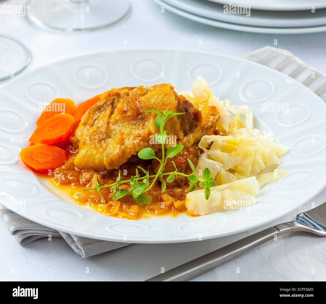 Gebratenes Huhn in Sauce mit Gemüse serviert. Stockfoto