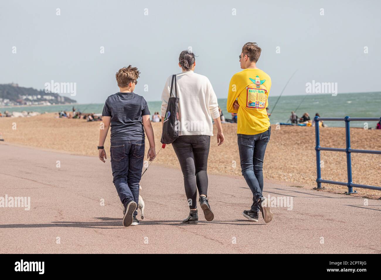 Eine Familie, die entlang einer Strandpromenade während der covid-19 Einschränkungen geht Stockfoto