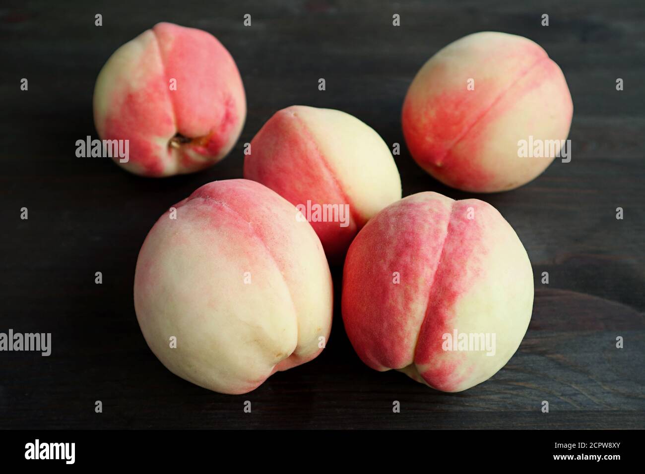 Haufen frischer reifer Pfirsiche auf schwarzem Hintergrund Stockfoto