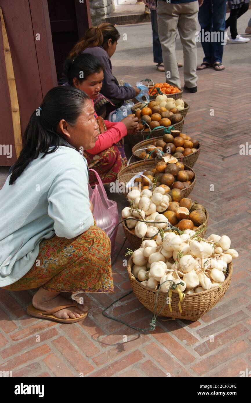 Junge Frauen verkaufen Obst, Blumen und Gemüse auf den Straßen von Luangphrabang, Laos. Stockfoto