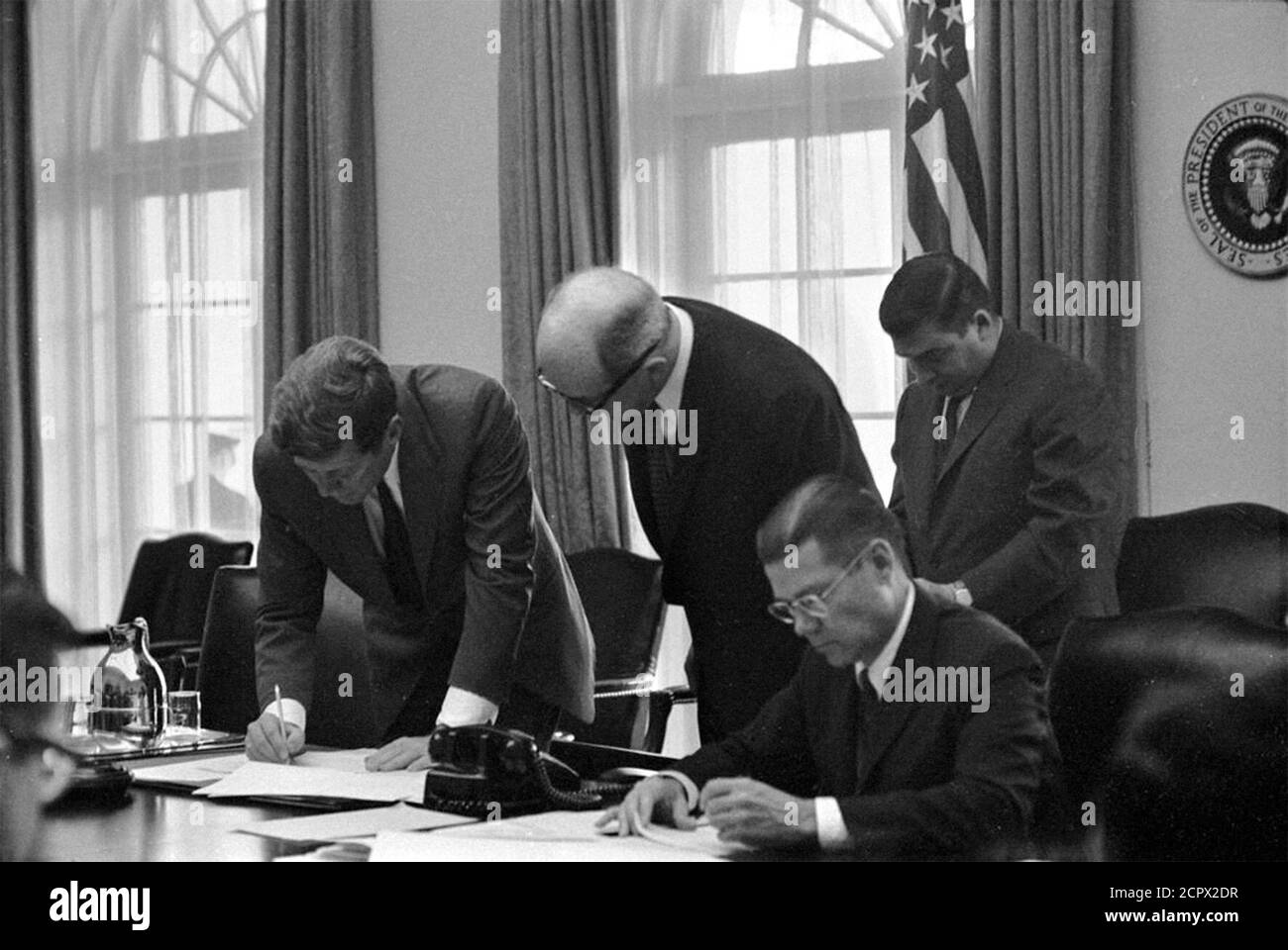 Kuba-Krise. Präsident John F Kennedy, Staatssekretär Dean Rusk, Verteidigungsminister Robert S. McNamara (sitzend) und Pressesprecher des Weißen Hauses Pierre Salinger im Kabinett im Oktober 1962 bei einem Treffen der EXCOMM, um die Krise in Kuba zu diskutieren. Stockfoto
