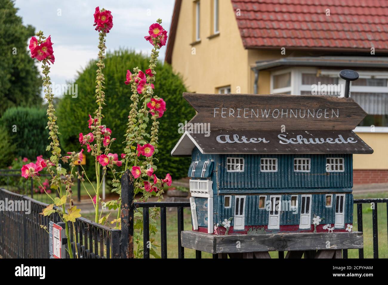 Deutschland, Mecklenburg-Vorpommern, Seebad Sellin, Kreis Seedorf, eine Malwee blüht neben einem Holzhaus mit der Aufschrift 'Ferienwohnungen Stockfoto