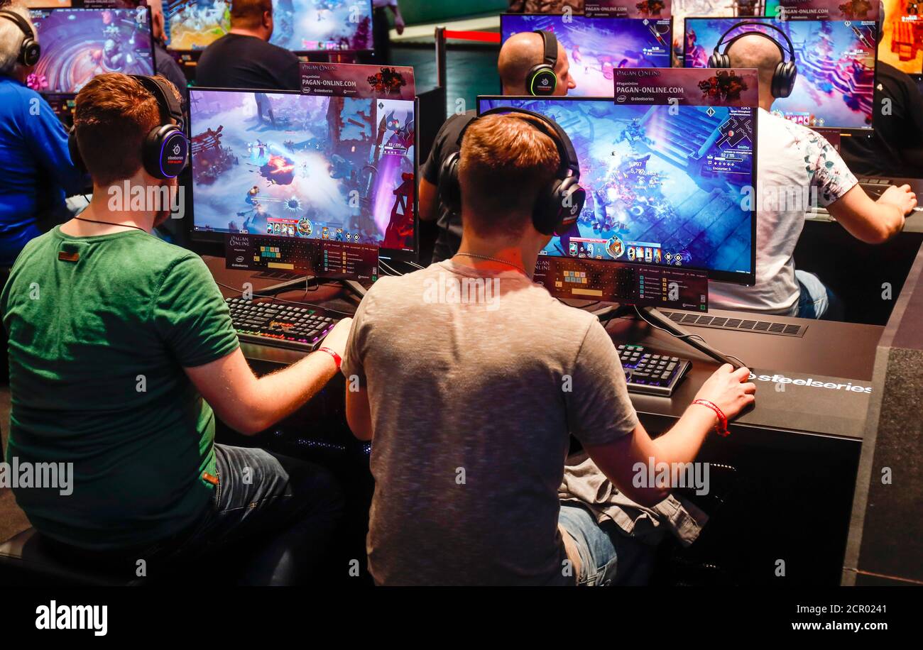 Besucher spielen Computerspiele vor Bildschirmen, Fachmesse für Computer- und Videospiele Gamescom, Köln, Nordrhein-Westfalen, Deutschland Stockfoto