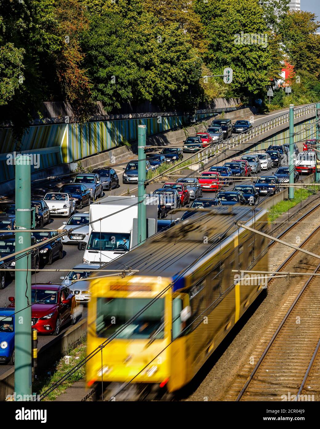 Verkehrsstau auf der Autobahn A40 und freie Fahrt mit der U-Bahn U18, Essen, Ruhrgebiet, Nordrhein-Westfalen, Deutschland Stockfoto