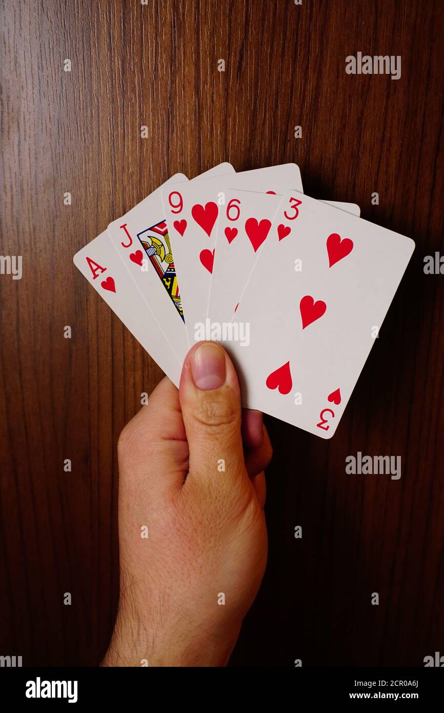 Poker-Karten mit verschiedenen Kombinationen in Mann Hand Nahaufnahme Und isolierter Hintergrund Stockfoto