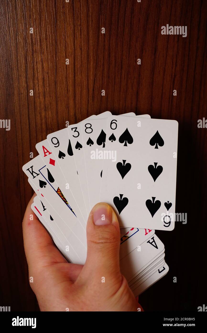 Poker-Karten mit verschiedenen Kombinationen in Mann Hand Nahaufnahme Und isolierter Hintergrund Stockfoto