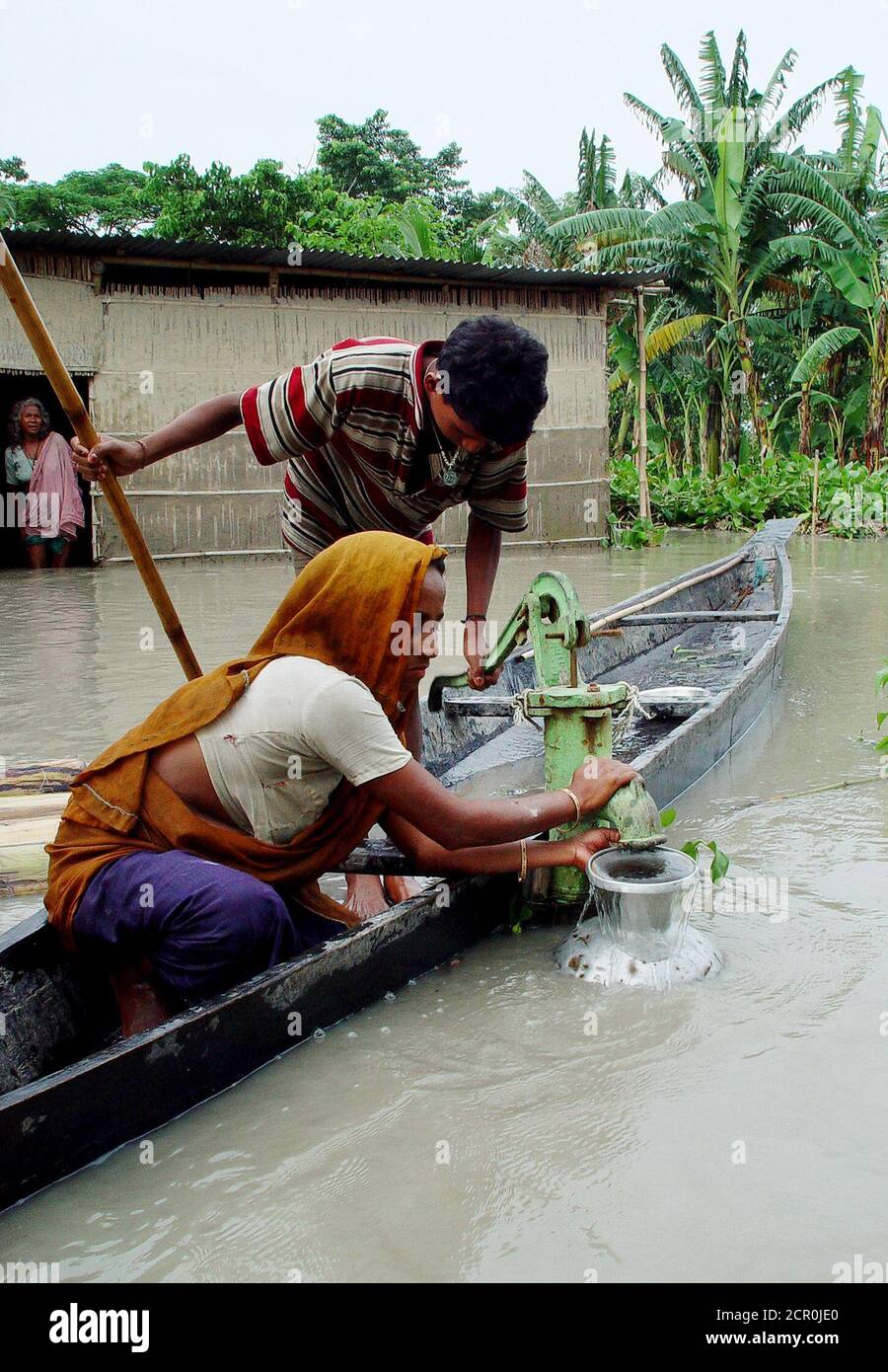 Dorfbewohner sammeln Trinkwasser aus einem Staurohr bei Hirajani Dorf etwa  50 km (31 Meilen) westlich von Guwahati, der Hauptstadt des nordöstlichen  indischen Bundesstaat Assam, 11. Juli 2004. Mindestens 40 Menschen,  verpackt in