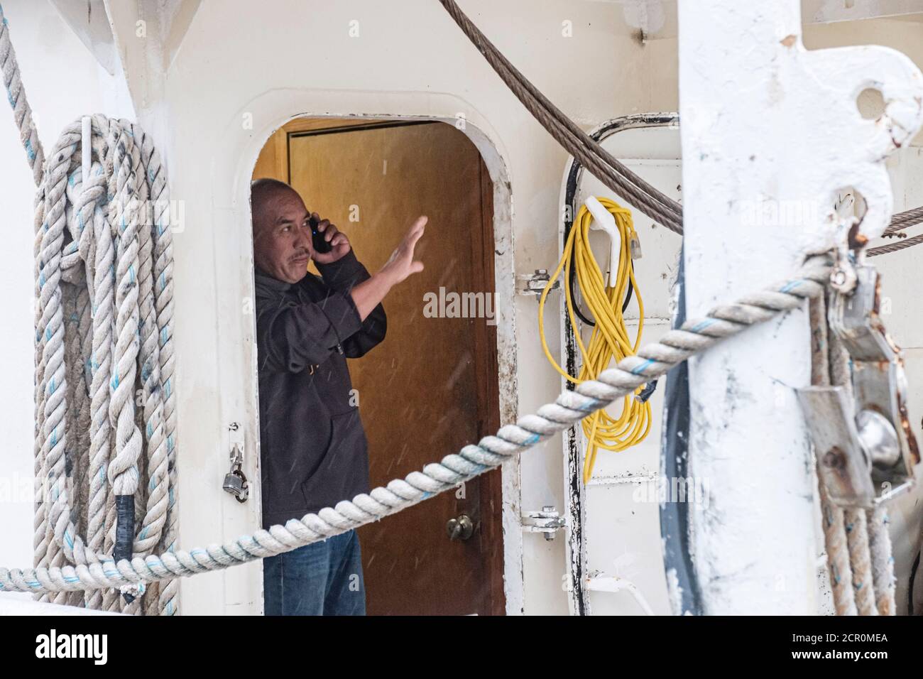 Bayou La Batre, ALABAMA, USA. September 2019. Ein Mann schaut aus seinem Fischerboot, als Hurrikan Sally Regen und Wind in Bayou La Batre, Alabama, USA am 15. September 2020 schiebt. Hurrikan Sally wird als Kategorie-2-Hurrikan Land machen. Quelle: Dan Anderson/ZUMA Wire/Alamy Live News Stockfoto