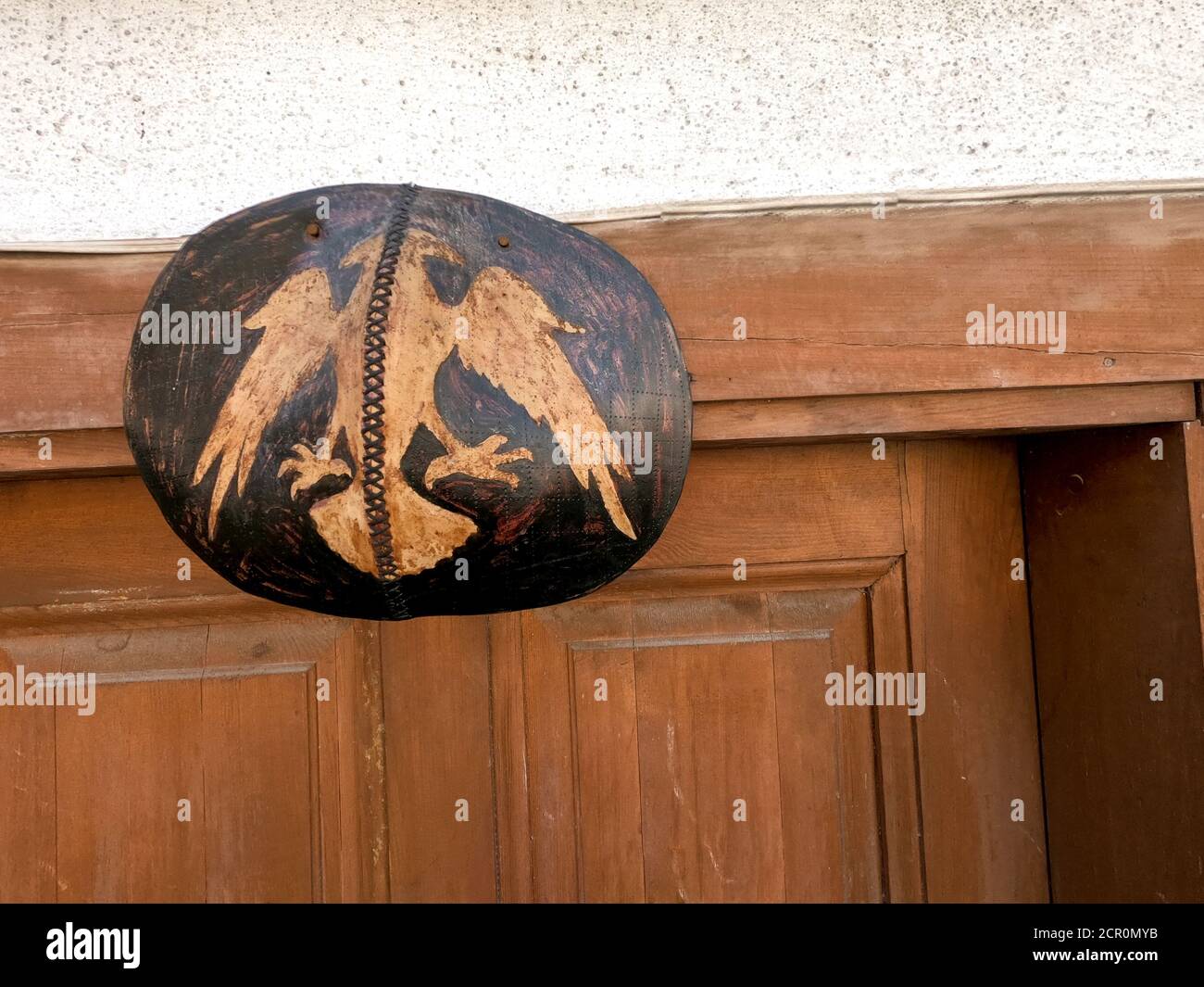 Doppelköpfiger Falke Symbol von albanien auf der Oberseite der Holztür Stockfoto