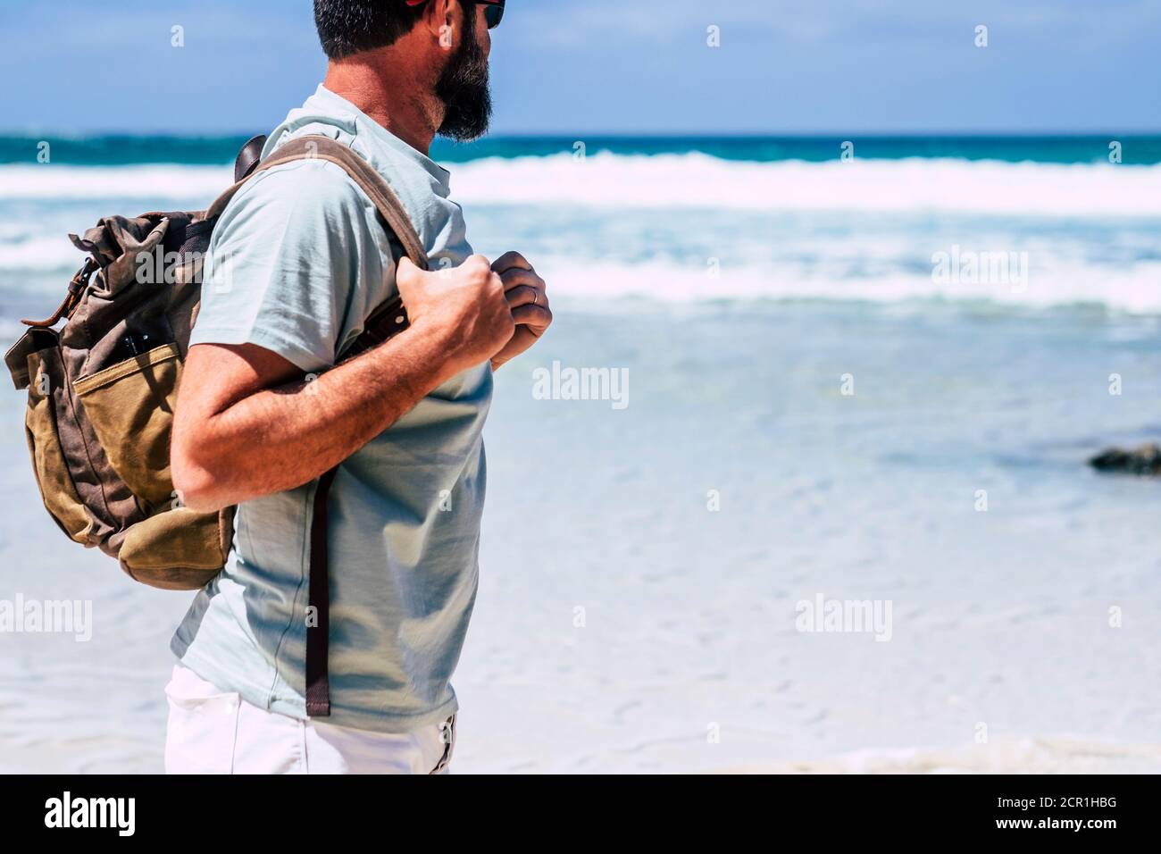 Reise- und Sommerurlaub Menschen Konzept mit Erwachsenen kaukasisch Männchen mit Bart und Rucksack Blick auf den Ozean stehend Am Strand - blau Stockfoto Reise- und Sommerurlaub Menschen Konzept mit Erwachsenen kaukasisch Männchen mit Bart und Rucksack Blick auf den Ozean stehend Am Strand - blau Stockfoto