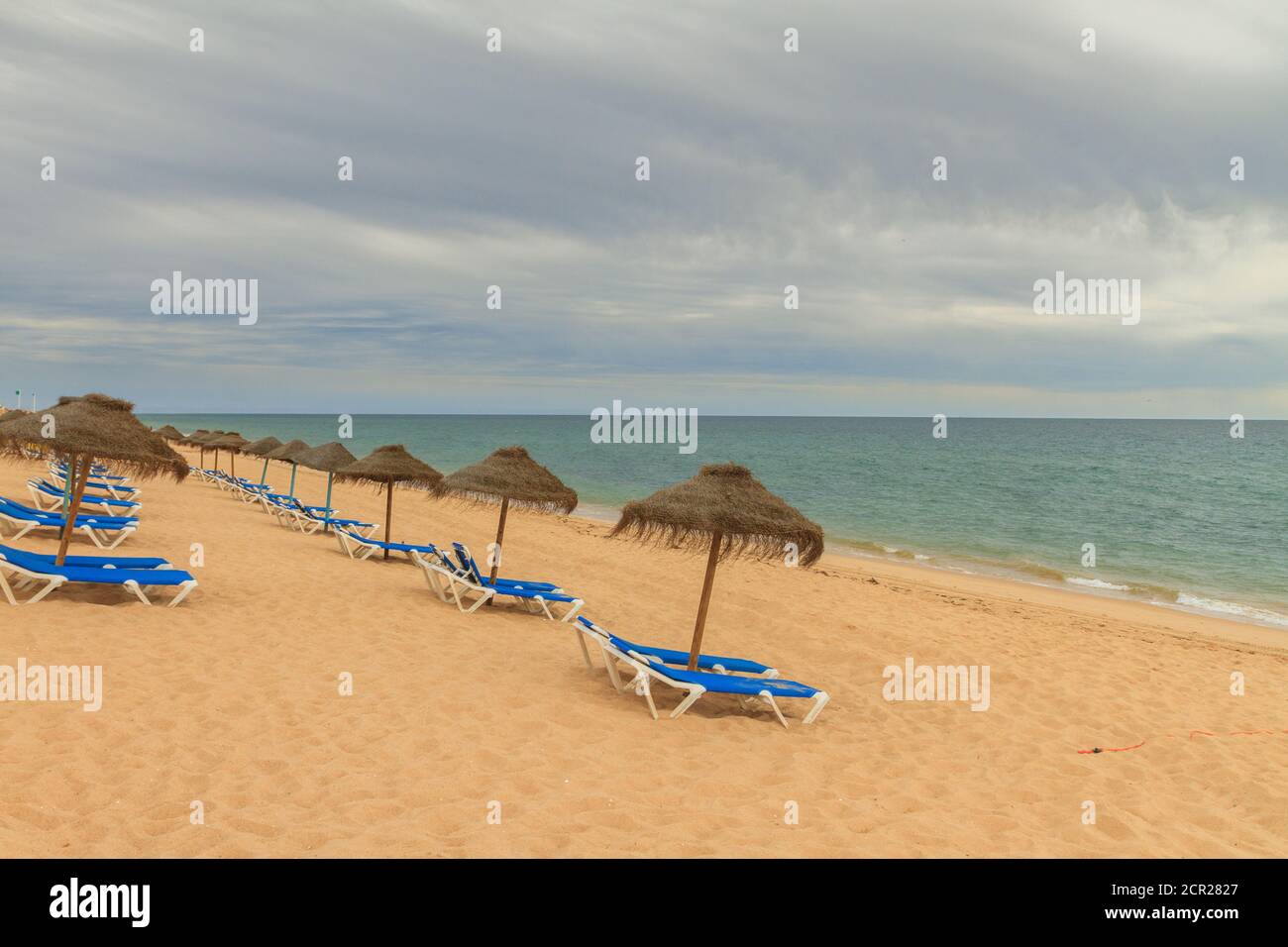 Leerer einsamer Strand mit niemand in den Liegestühlen in Faro, Algarve während der Covid-19 Pandemiebeschränkungen. Stockfoto