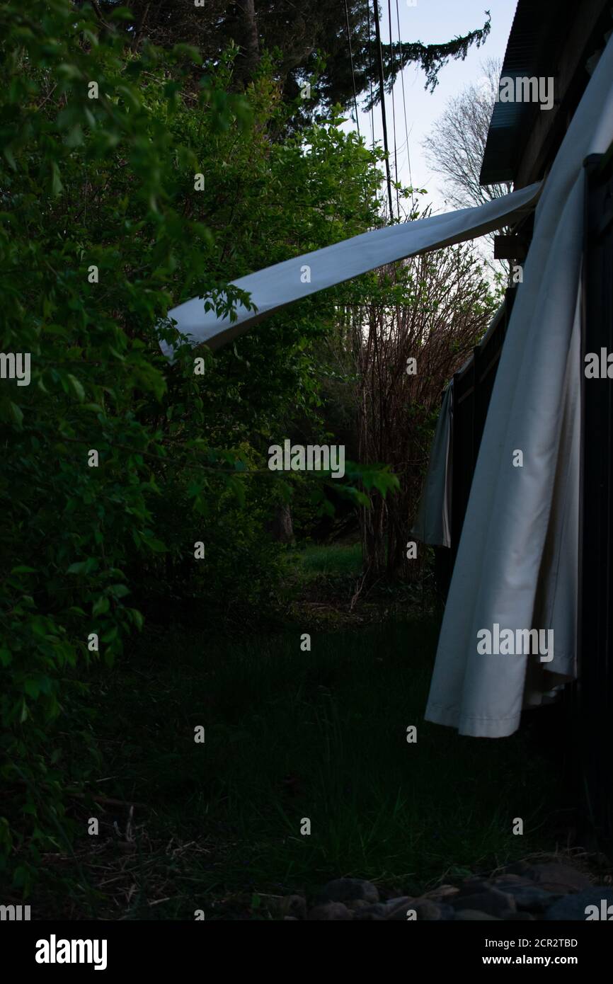 Weiße Vorhänge auf einer Terrasse im Freien weht heftig in die Wind Stockfoto